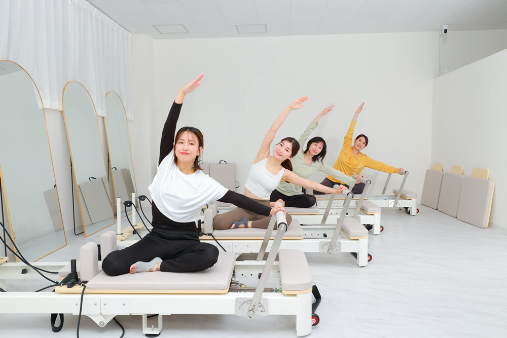5pilatesのスタジオで複数人がリフォーマーを使っている様子